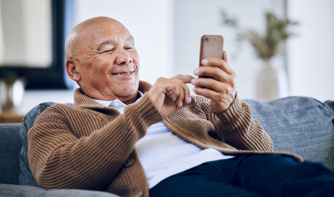 Senhor aposentado com celular na mão